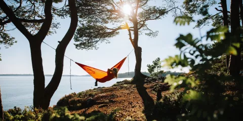 Kvinna i hängmatta vid fjorden